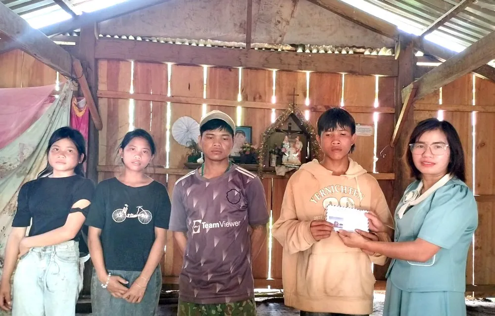 Bà Mai Thị Luận (ngoài cùng bên phải) trao số tiền bạn đọc Báo SGGP hỗ trợ cho các con ông A PLớp