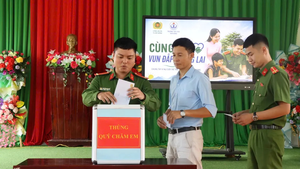Các chiến sĩ công an cùng lãnh đạo trường tham gia ủng hộ Thùng quỹ chăm em. Ảnh: HỮU PHÚC