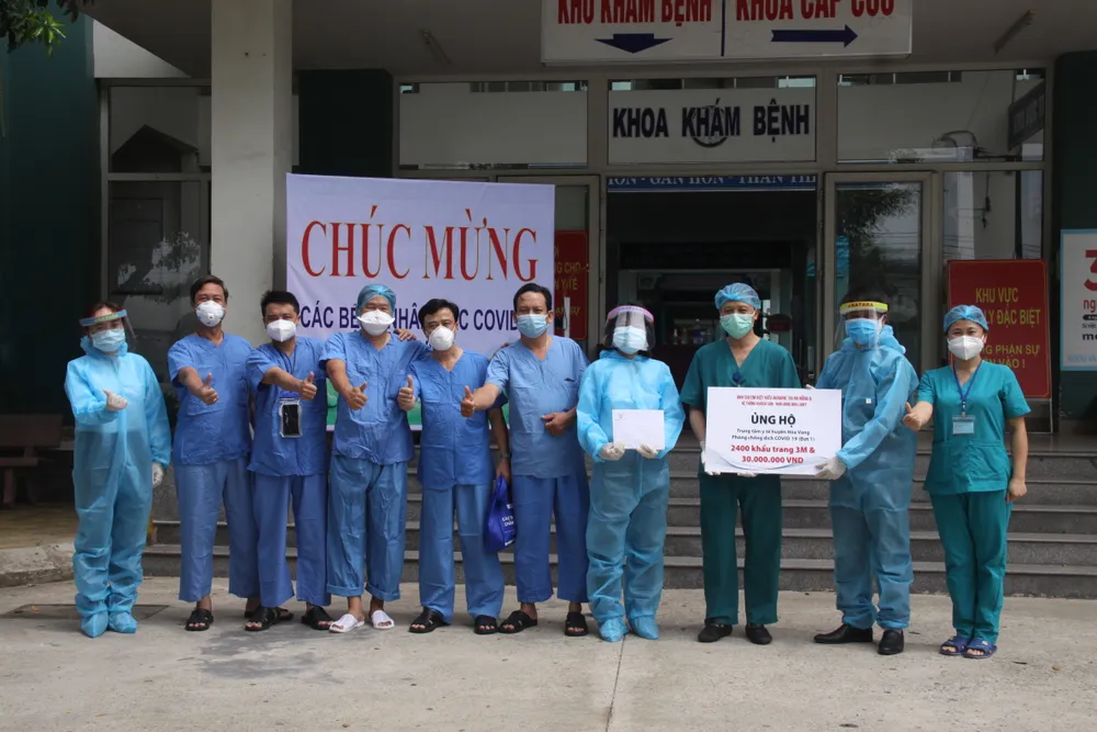 Bác sĩ Nguyễn Đại Vĩnh, Giám đốc Trung tâm Y tế Hòa Vang và đoàn bác sĩ Bệnh viện Chợ Rẫy chi viện cho BV dã chiến-TTYT Hòa Vang vui vẻ nhận quà 30 triệu đồng và 2.400 khẩu trang 3M do Báo Công an và nhà tài trợ trao tặng