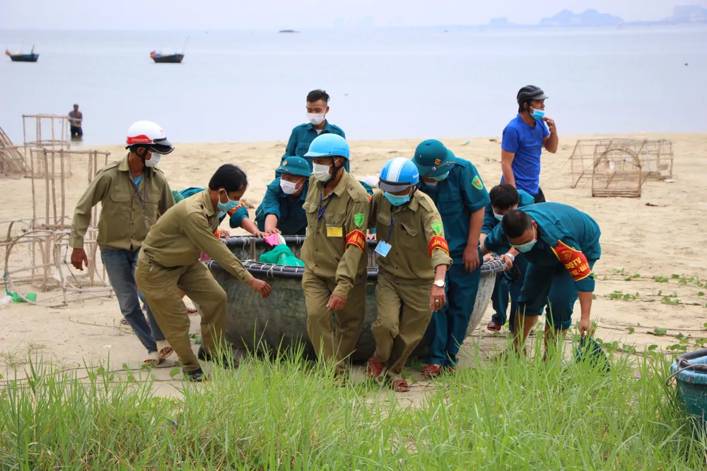 Lực lượng chức năng hỗ trợ ngư dân đưa thuyền thúng lên bờ