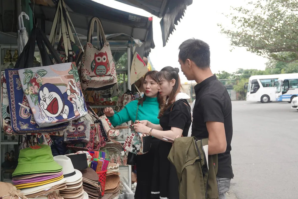 Du khách tham quan một số đồ dùng lưu niệm. Ảnh: XUÂN QUỲNH