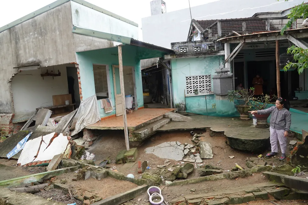 Chị Nguyễn Thị Quế chỉ tay đến căn nhà sinh sống mấy năm nay đã không còn do mưa lũ ngày 14-10-2022