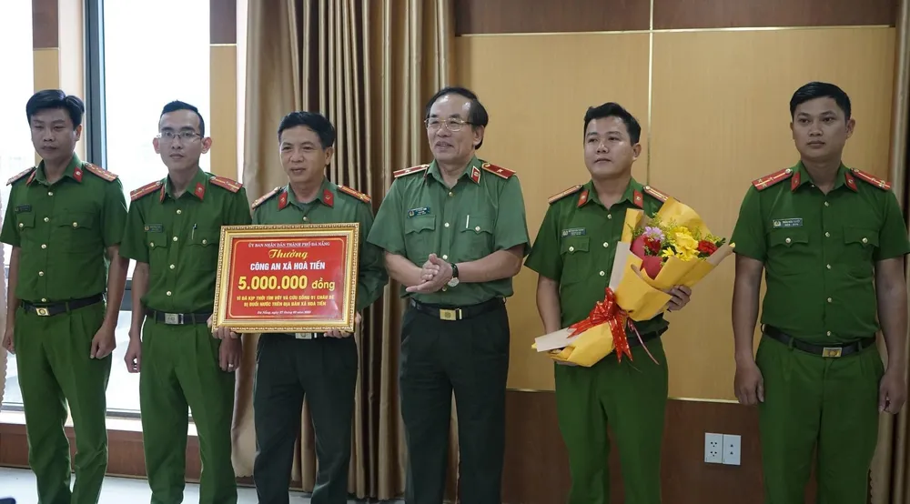 Thừa ủy quyền của Chủ tịch UBND TP Đà Nẵng, Thiếu tướng Vũ Xuân Viên trao thưởng cho Công an xã Hòa Tiến. Ảnh: CATP