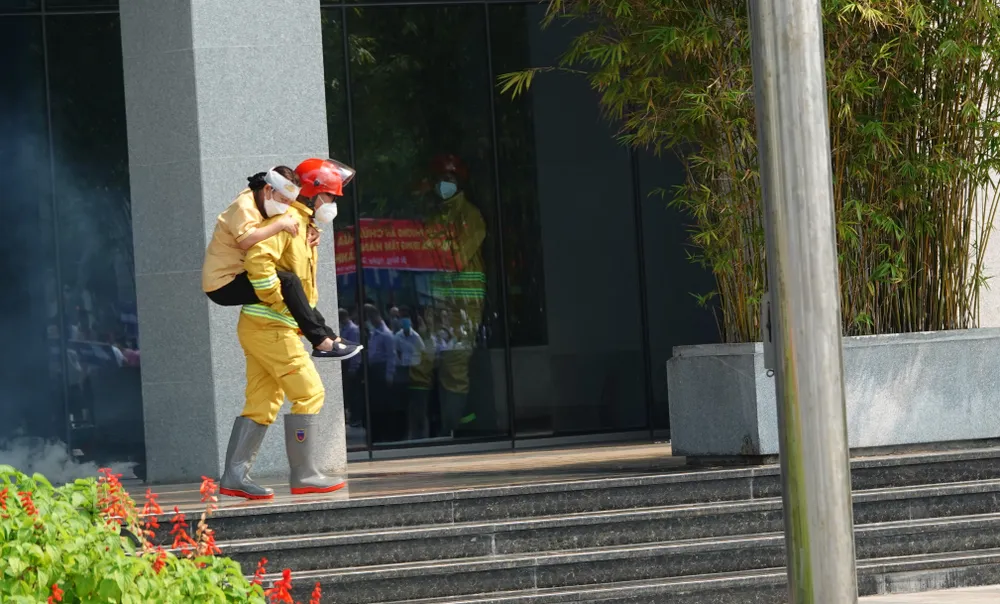 Một chiến sĩ cõng người bị thương ra khỏi tòa nhà tại cửa số 1. Ảnh: XUÂN QUỲNH Một chiến sĩ cõng người bị thương ra khỏi tòa nhà tại cửa số 1. Ảnh: XUÂN QUỲNH