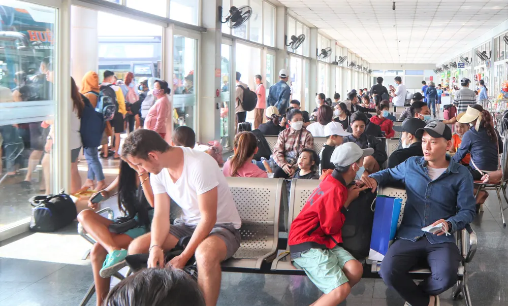 Du khách, người dân ngồi đợi ở Bến xe Đà Nẵng. Ảnh: XUÂN QUỲNH