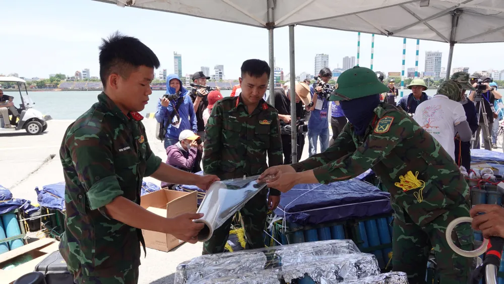 Lực lượng quân sự phối hợp đậy kín ngòi pháo. Ảnh: XUÂN QUỲNH