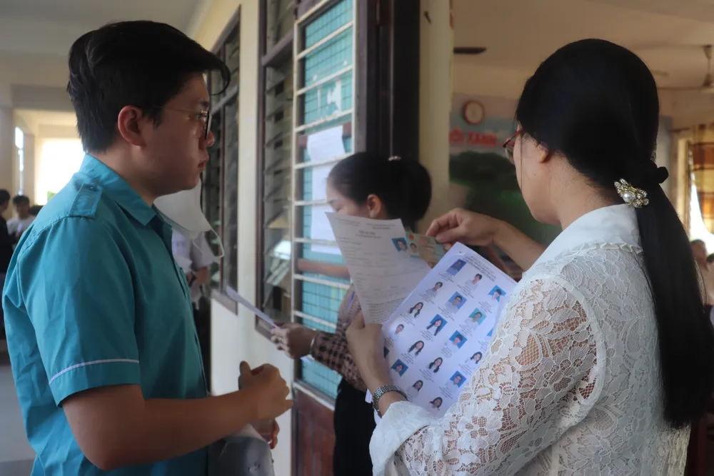 Cán bộ coi thi đọc số báo danh từng thí sinh để rà soát trước khi vào phòng thi. Ảnh: XUÂN QUỲNH