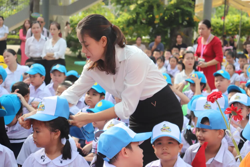 Các em học sinh được cô giáo chuẩn bị trước khi bắt đầu lễ khai giảng. Ảnh: XUÂN QUỲNH