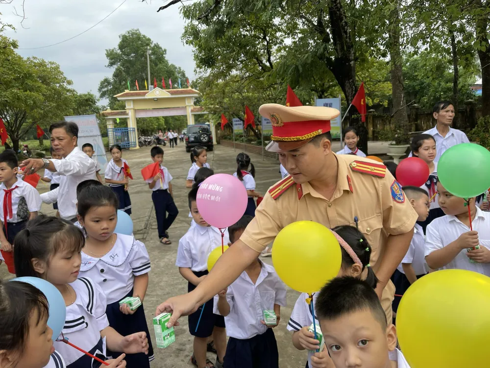 Lực lượng công an tặng sữa cho các em trong ngày khai giảng. Ảnh: VĂN THẮNG