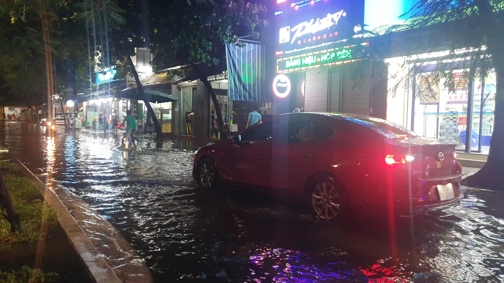 Ô tô phải đi lùi do đi vào đường ngập sâu. Ảnh: XUÂN QUỲNH