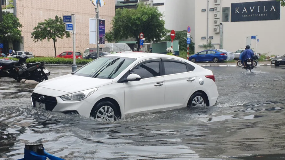Nước ngập đến nửa xe ô tô tại đường Lê Quý Đôn. Ảnh: XUÂN QUỲNH