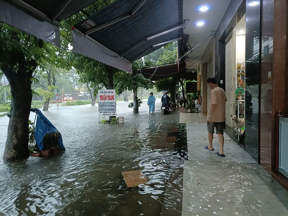 Người dân đi men theo sân nhà để di chuyển tại đường Bắc Sơn. Ảnh: XUÂN QUỲNH