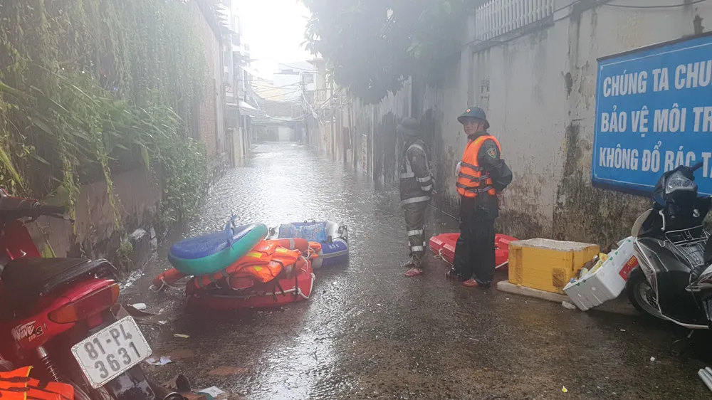 Lực lượng chức năng ngăn chặn người tự ý vào khu vực ngập lụt. Ảnh: XUÂN QUỲNH