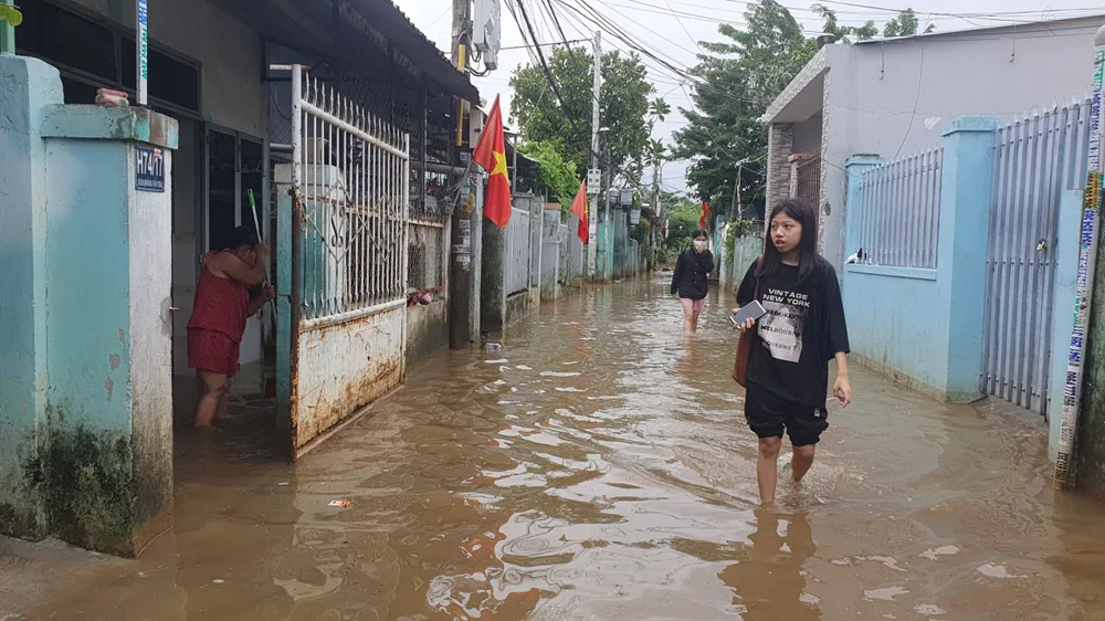 Mưa ngớt, người dân tổ 36 phường Hòa Khánh Nam về nhà nhưng lại phải trở ra vì vẫn còn ngập lụt sâu. Ảnh: XUÂN QUỲNH