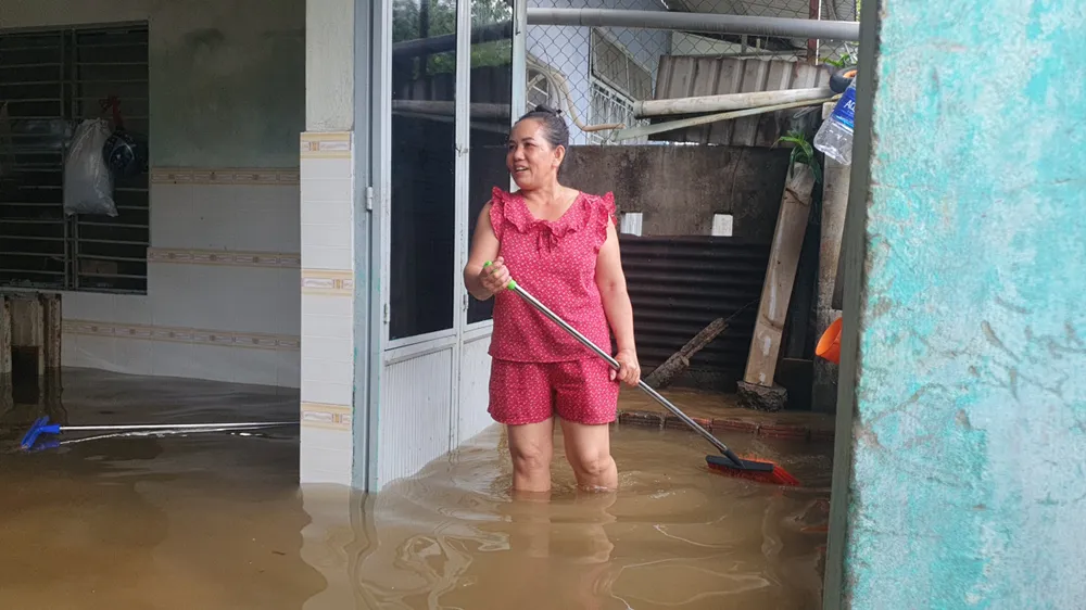 Bà Nguyễn Thị Ánh đã đẩy nước thoát ra ngoài. Ảnh: XUÂN QUỲNH