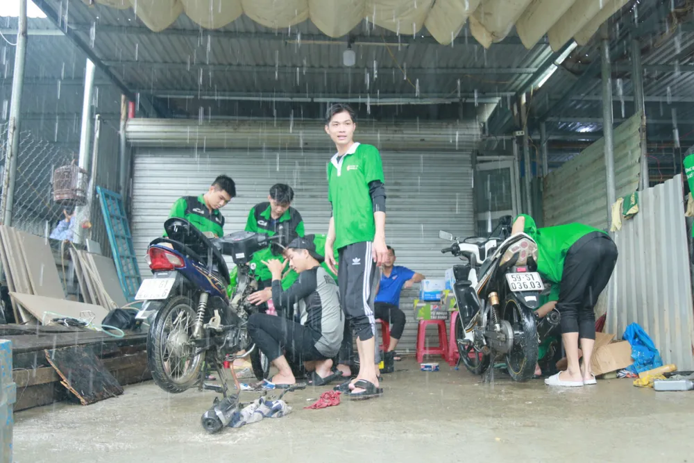 Thời tiết tại điểm sửa xe mưa khá to. Ảnh: XUÂN QUỲNH