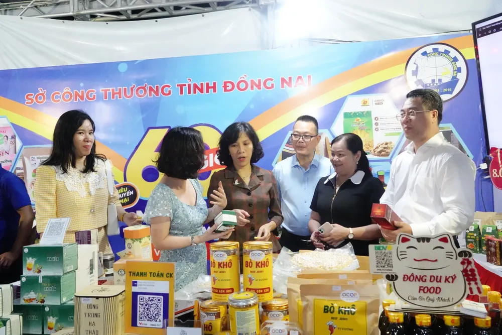 Bà Lại Việt Anh, Phó Cục trưởng Cục Thương mại điện tử và Kinh tế số (Bộ Công Thương) cùng lãnh đạo ngành Công Thương Đà Nẵng đến tham quan gian hàng. Ảnh: XUÂN QUỲNH