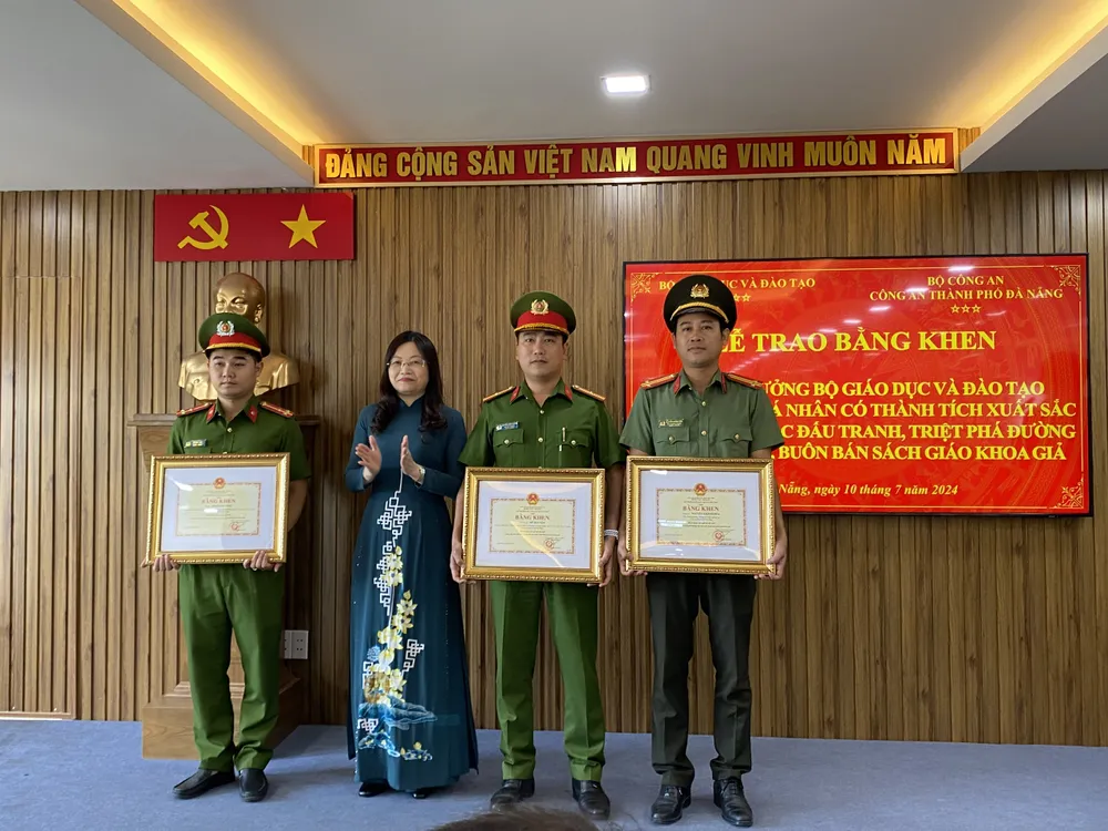 Thừa ủy quyền của Bộ trưởng Bộ GD-ĐT, bà Nguyễn Thị Hạnh trao Bằng khen cho 3 cá nhân. Ảnh: XUÂN QUỲNH