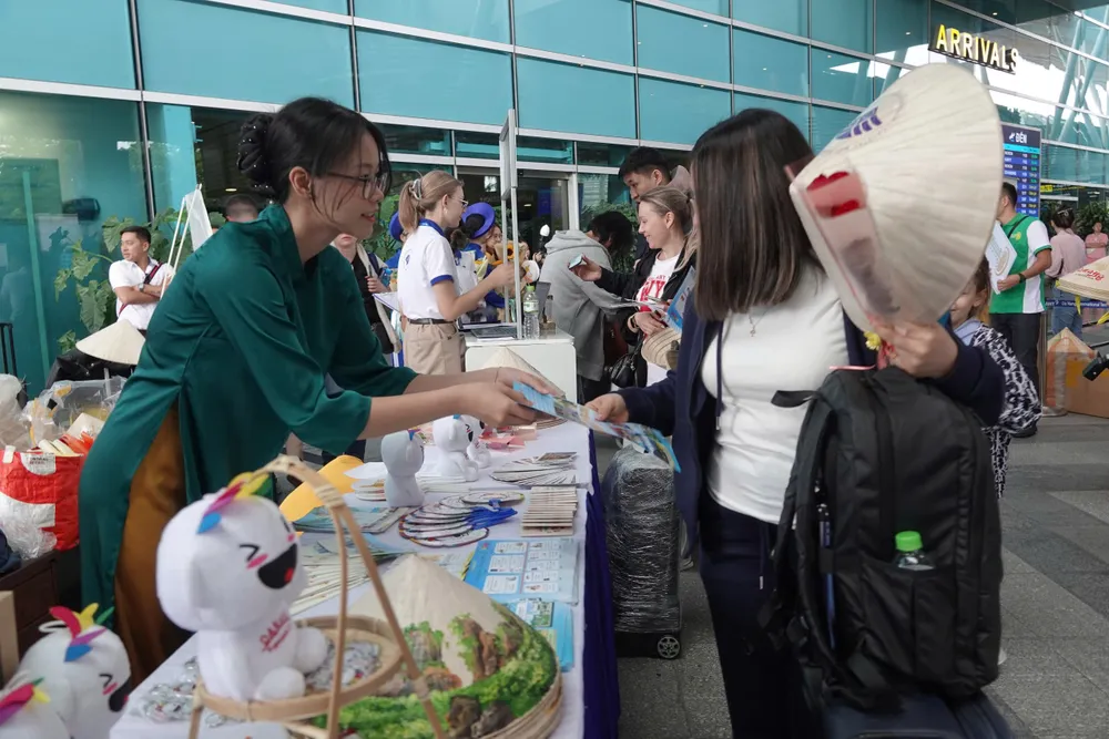 Khách du lịch đến từ CIS được tặng nón lá. Ảnh: XUÂN QUỲNH 