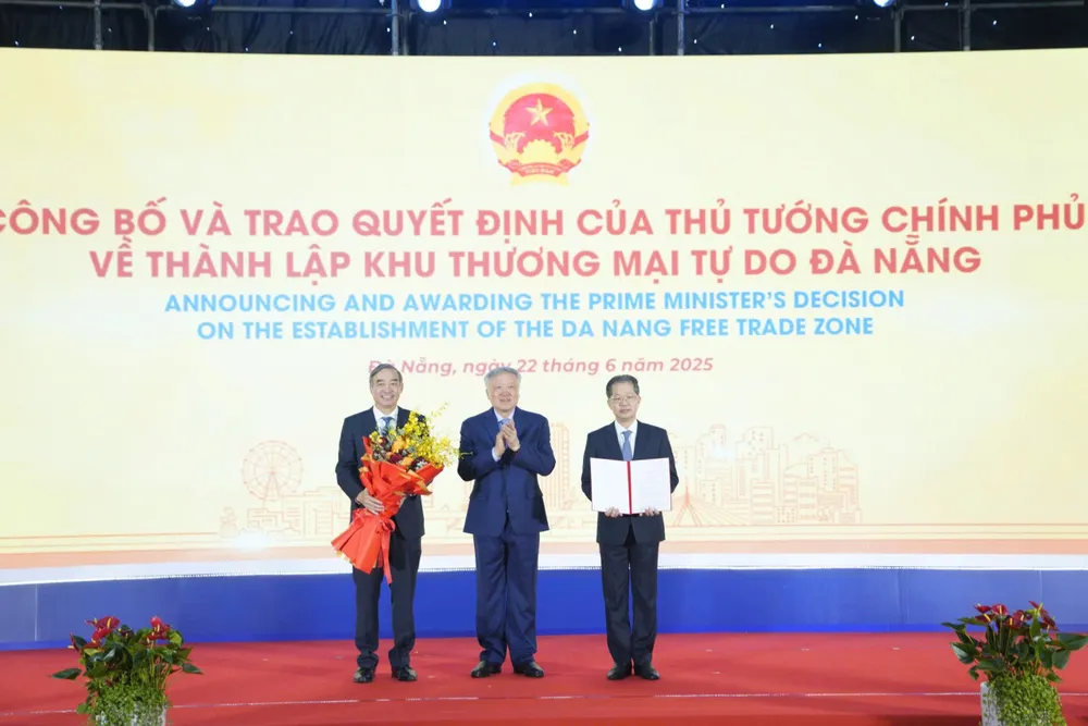 Phó Thủ tướng Thường trực Chính phủ Nguyễn Hòa Bình (giữa) trao Quyết định số 1142/QĐ-TTg ngày 13-6-2025 về việc thành lập Khu thương mại tự do Đà Nẵng cho lãnh đạo TP Đà Nẵng. Ảnh: XUÂN QUỲNH