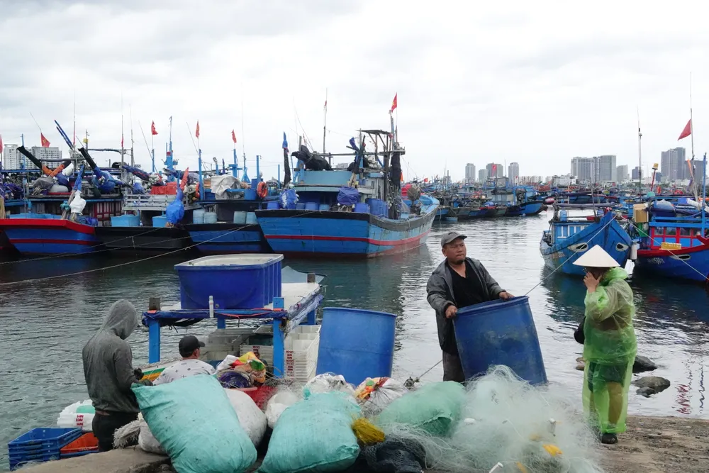 Các thuyền viên tất bật chuyển vật dụng từ ghe lên bờ. Ảnh: XUÂN QUỲNH
