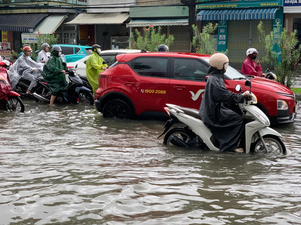 Mực nước ngập gần nửa bánh xe. Ảnh: THIÊN VŨ