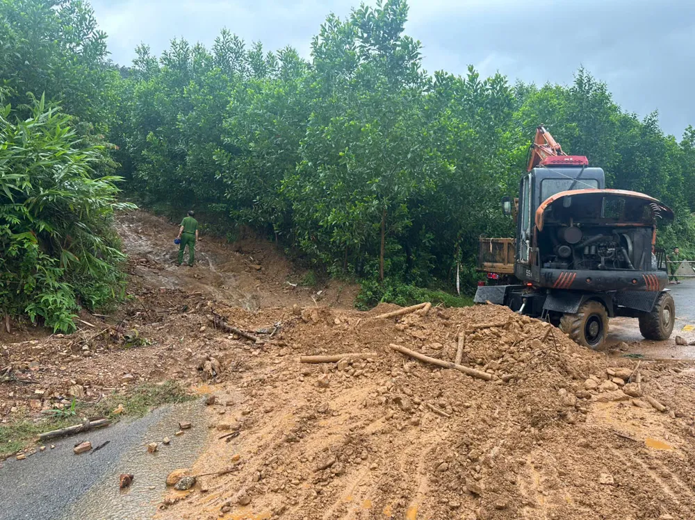 Lực lượng chức năng xử lý đoạn đường sạt lở. Ảnh: BÙI HỒNG TRUNG