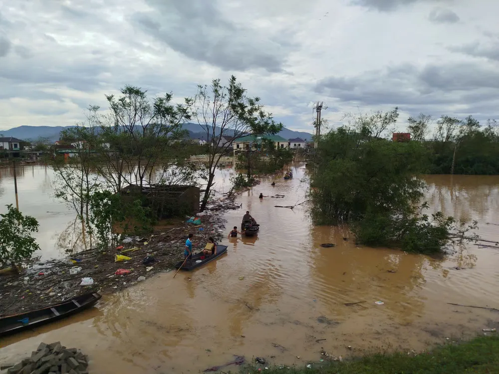 Thuyền chở người dân ra khỏi xóm bị ngập lũ