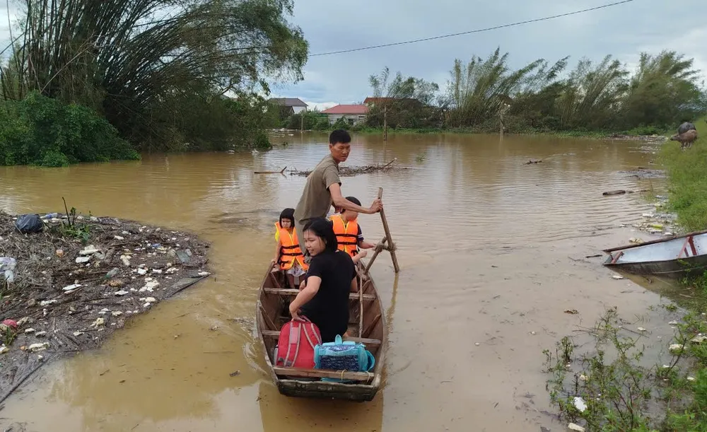 Trẻ em mặc áo phao ngồi trên thuyền, được đưa ra khỏi vùng ngập lũ