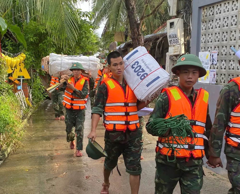 Cán bộ, chiến sĩ mang theo bao tải, dây thừng để gia cố tạm thời bờ kè hạn chế xâm thực