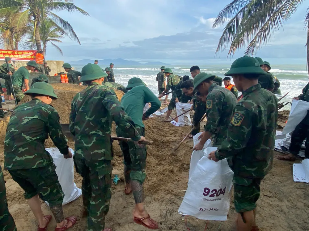 Bộ đội xúc cát đổ vào bao tải để gia cố bờ kè