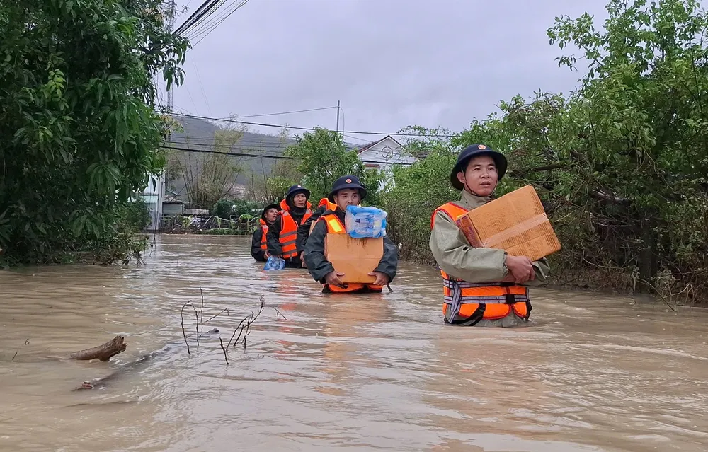 Các chiến sĩ lội nước vận chuyển nhu yếu phẩm hỗ trợ người dân