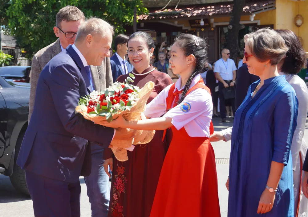 Học sinh tặng hoa chào mừng Thủ tướng Ba Lan Donald Tusk đến tham quan phố cổ Hội An