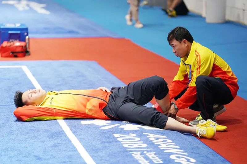 Võ sĩ Trần Xuân Hiệp được bác sĩ chăm sóc. Ảnh: DŨNG PHƯƠNG