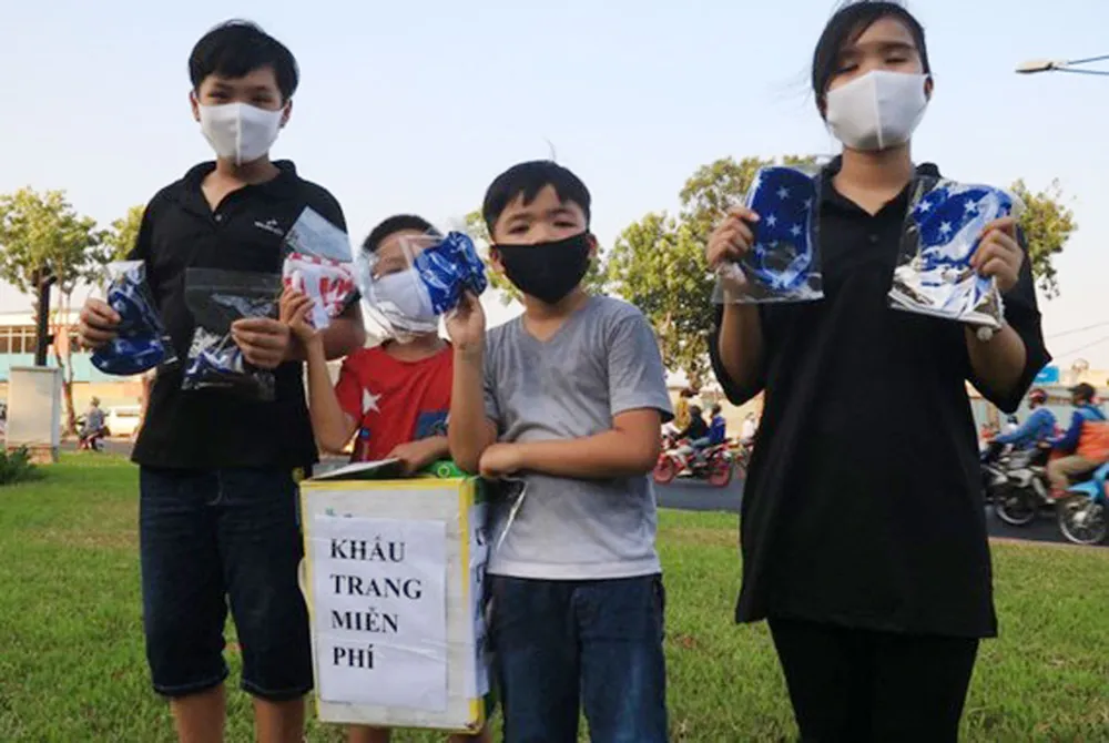 Nhóm học sinh phát khẩu trang vải miễn phí cho người đi đường
