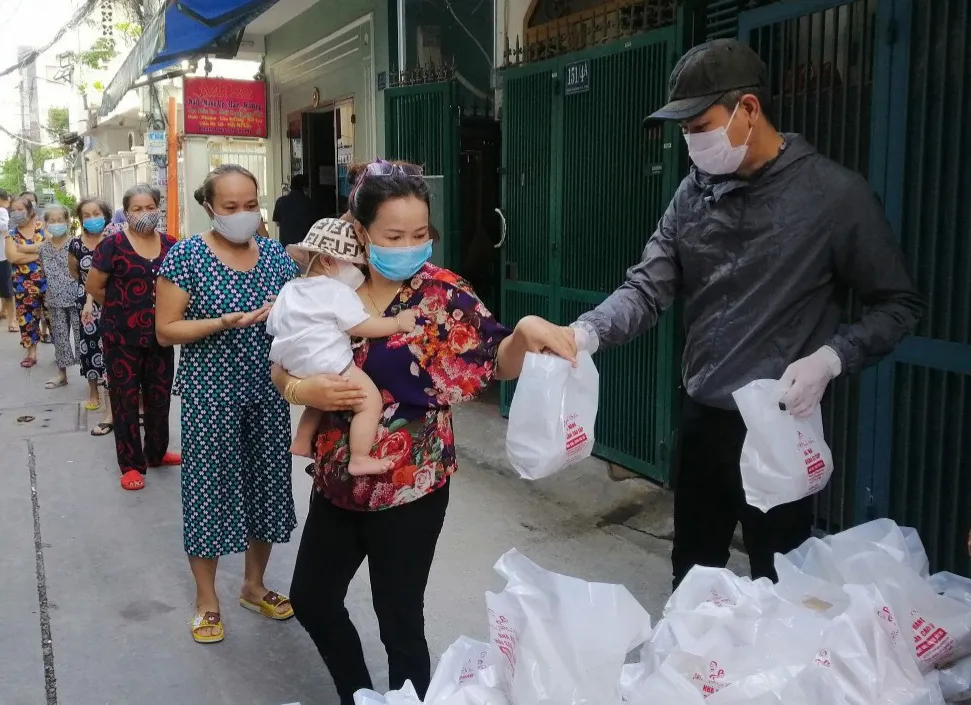 Anh Huỳnh Duy Quang Tố, Tổ phó Tổ dân phố 27, khu phố 3, phường 11 (quận Phú Nhuận, TPHCM) phát lương thực thiết yếu cho người dân có hoàn cảnh khó khăn trong tổ