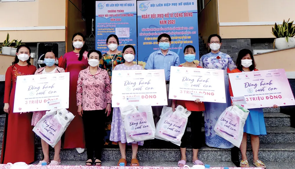 PGS-TS Trương Thị Hiền, Chủ tịch Hội nữ Trí thức TPHCM cùng đại diện Hội Liên hiệp Phụ nữ TPHCM, Báo SGGP  trao quà cho các thai phụ. Ảnh: VIỆT NGA