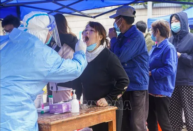 Nhân viên y tế lấy mẫu xét nghiệm cho người dân Thượng Hải ngày 26-3-2022. Ảnh: THX/TTXVN