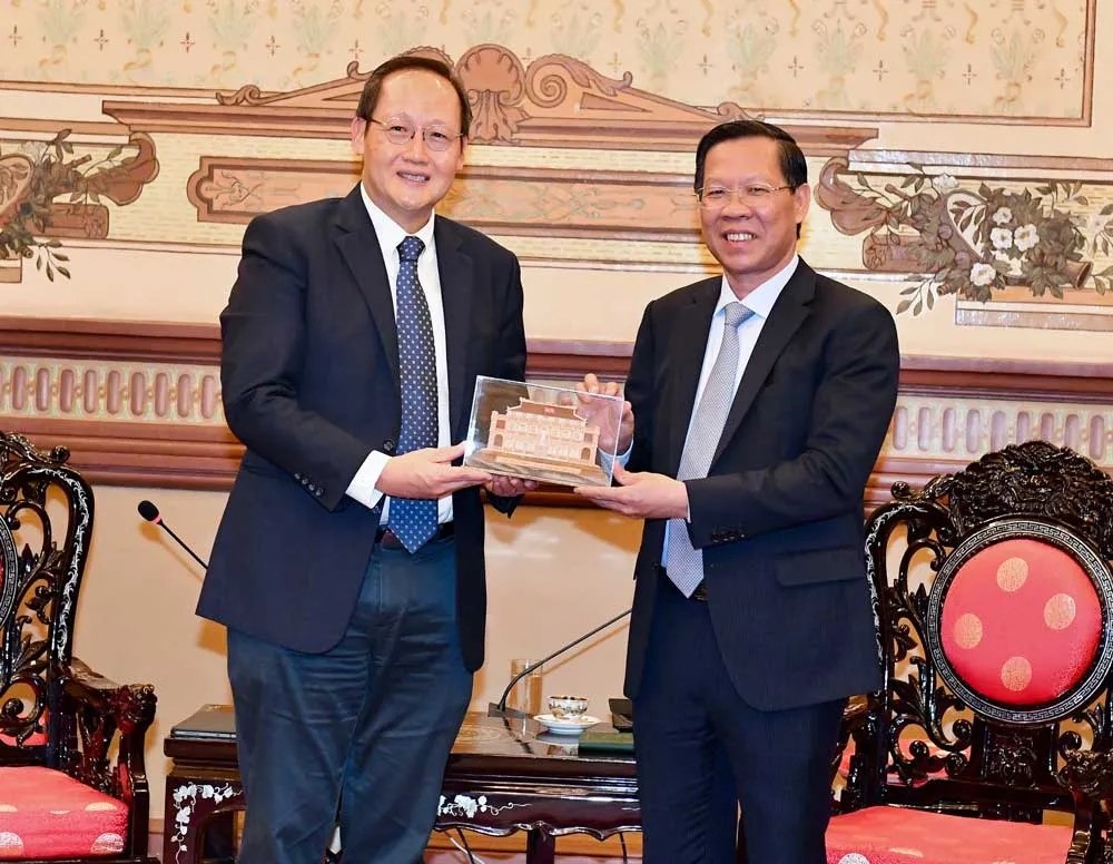 Chủ tịch UBND TPHCM Phan Văn Mãi  tặng quà lưu niệm ông Tan See Leng. Ảnh: VIỆT DŨNG
