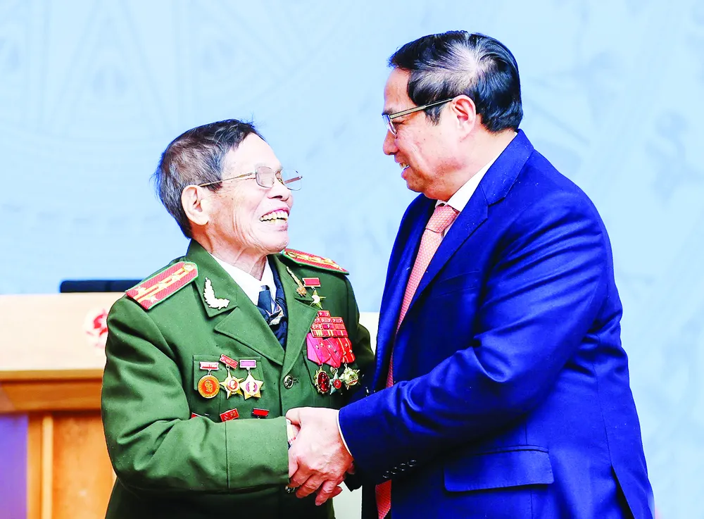 Thủ tướng Phạm Minh Chính thăm hỏi nhân chứng lịch sử của lực lượng Công an nhân dân. Ảnh: VIẾT CHUNG