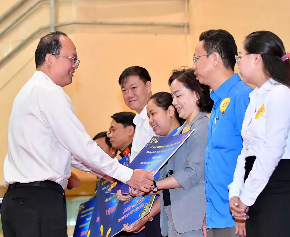 Phó Bí thư Thành ủy TPHCM Nguyễn Hồ Hải trao bảng kinh phí cho các đơn vị để chăm lo tết cho người dân. Ảnh: VIỆT DŨNG