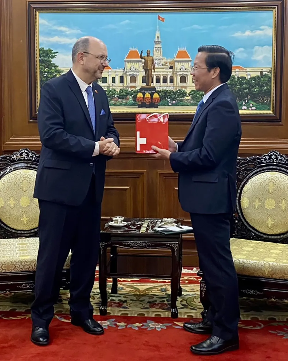 Đồng chí Phan Văn Mãi nhận quà lưu niệm từ Đại sứ Thụy Sĩ Thomas Gass. Ảnh: THANH HẰNG