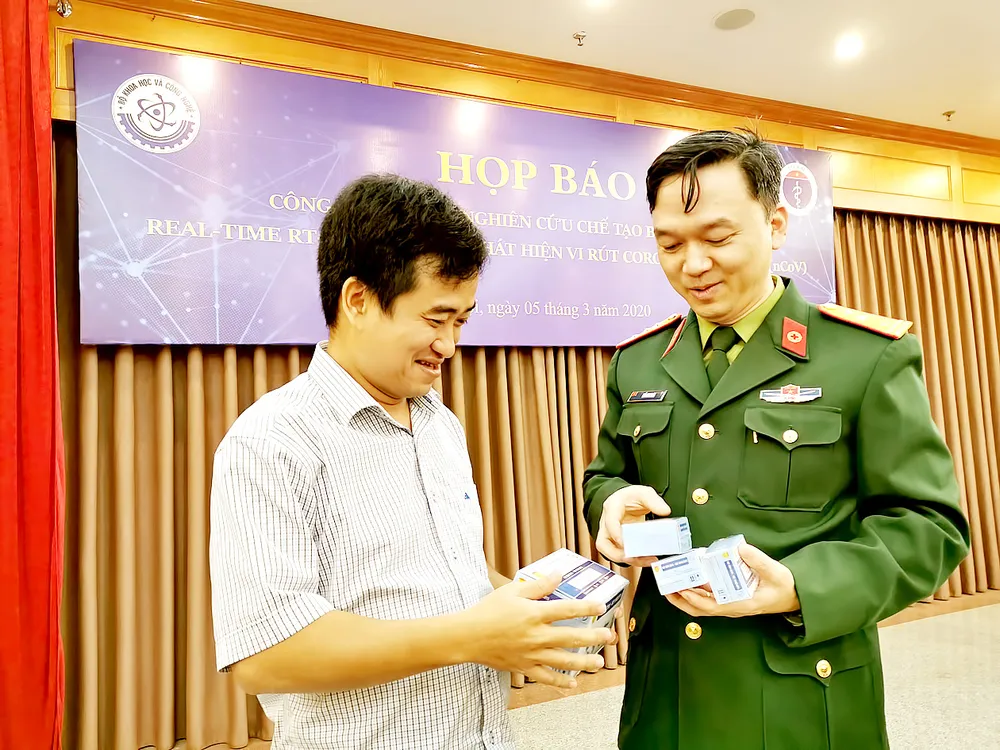 Phan Quốc Việt (trái) trong buổi họp báo giới thiệu bộ kit test Covid-19, tháng 3-2020