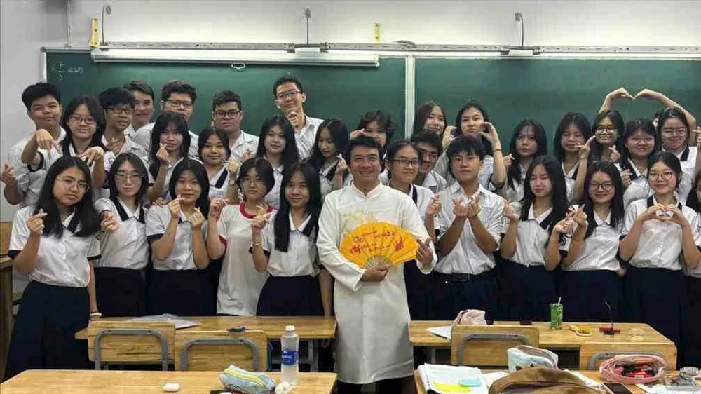 Học sinh chụp hình kỷ niệm cùng thầy giáo trong trang phục áo dài