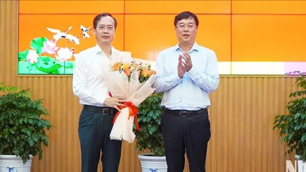 Bí thư Tỉnh ủy Đồng Tháp Lê Quốc Phong (bìa phải) trao hoa chúc mừng đồng chí Trần Trí Quang