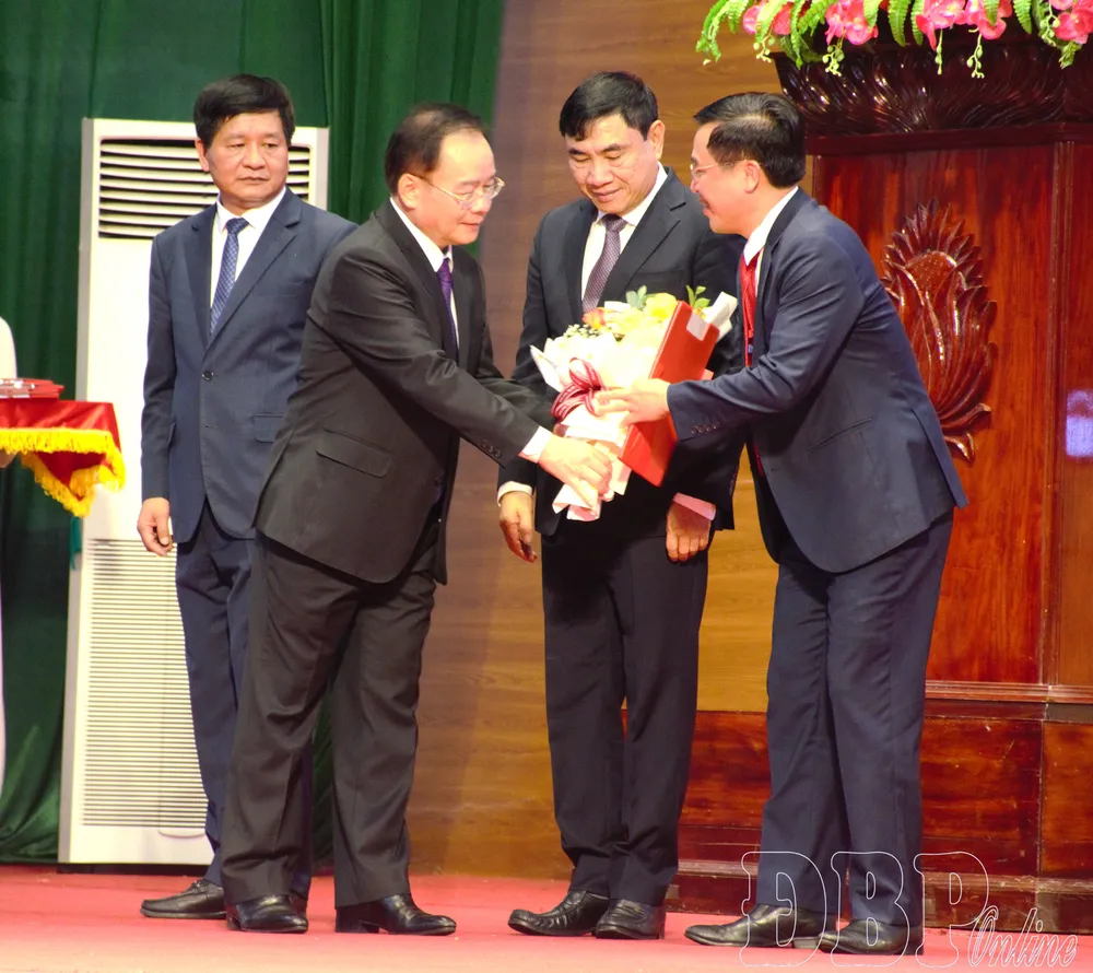 Phó Bí thư Thường trực Tỉnh ủy Mùa A Sơn tặng hoa chúc mừng Bí thư Đảng ủy, Chủ tịch HĐND xã Nà Hỳ. Ảnh: BÁO ĐIỆN BIÊN