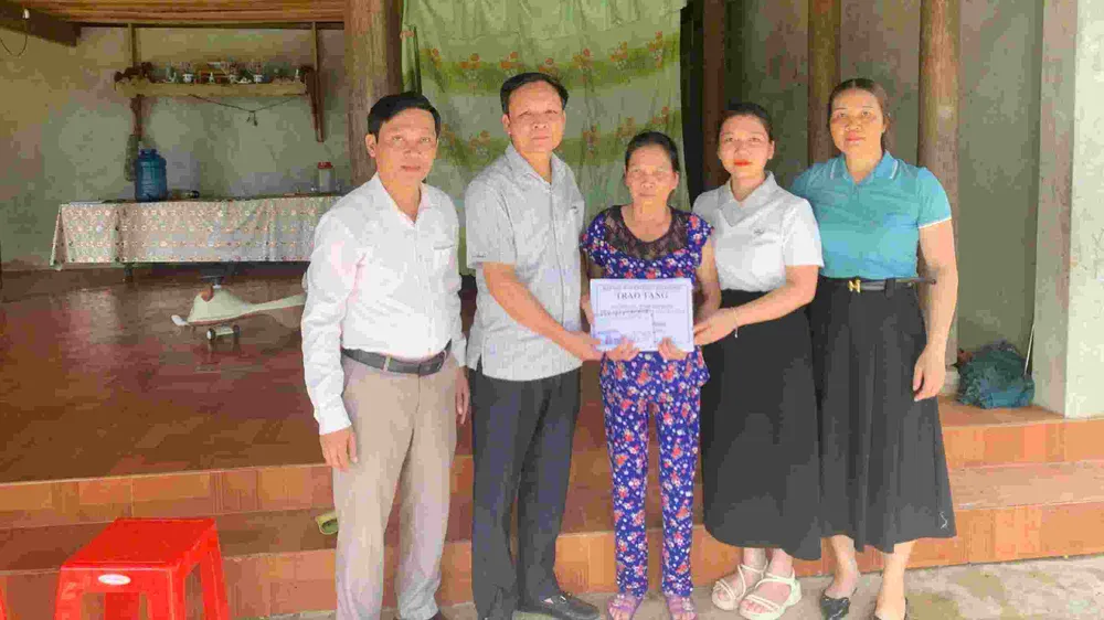 Lãnh đạo UBND xã Hương Xuân trao 9 triệu đồng của bạn đọc Báo SGGP hỗ trợ bà Đinh Thị Dung