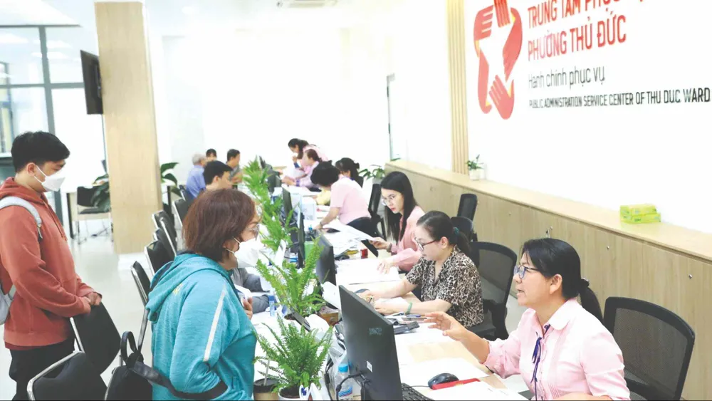 Công chức phường Thủ Đức (TPHCM) giải quyết thủ tục hành chính cho người dân. Ảnh: THU HƯỜNG