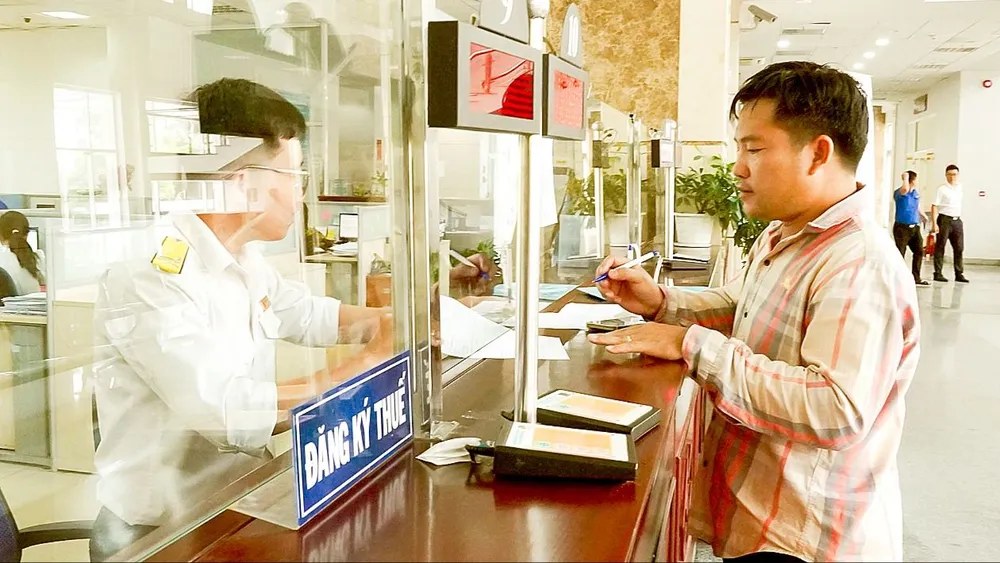 Người dân làm thủ tục thuế. Ảnh: HOÀNG HÙNG