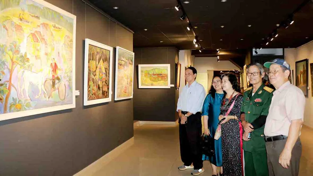 Vợ chồng họa sĩ Phan Oánh - Đặng Thị Dương và khách tham quan tại triển lãm “Hai đường thẳng song song - Một điểm đến”